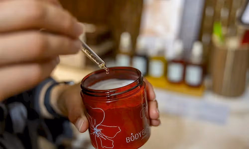 Dropper of essential oil being put in body butter